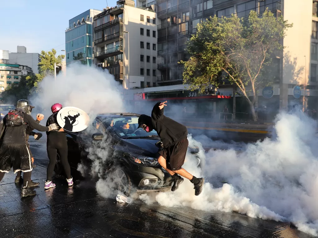 Sebuah kendaraan menabrak seorang demonstran selama protes terhadap pemerintah Chili (REUTERS/Ivan Alvarado)
