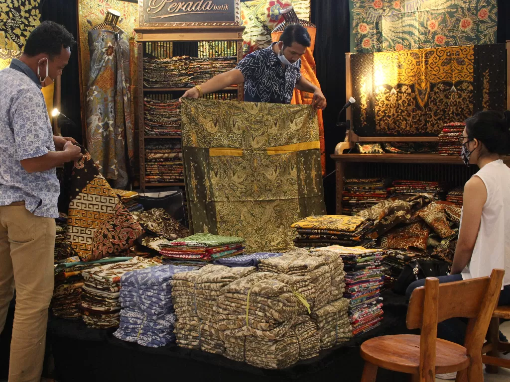 Pekerja menunjukan kain batik kepada pengunjung (ANTARA FOTO/Didik Suhartono)