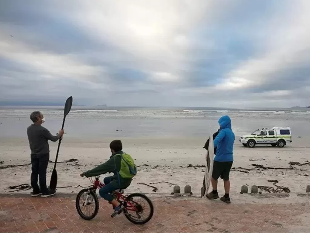 Polisi berpatroli saat peselancar dan pengunjung di pantai Muizenberg, Cape Town, Afrika Selatan, Selasa (5/5/2020). (Photo/EUTERS/Mike Hutchings)