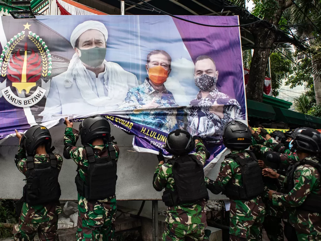 Prajurit TNI menertibkan spanduk tidak berizin saat patroli keamanan di Petamburan, Jakarta, Jumat (20/11/2020). (Antara/Aprillio Akbar)