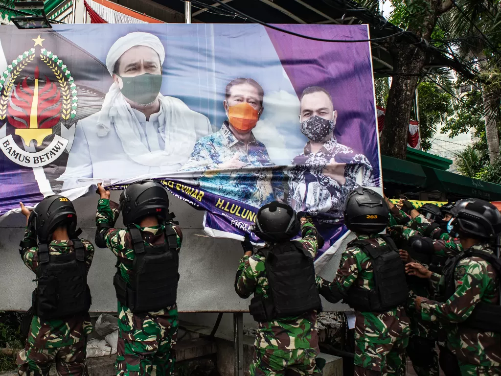 Prajurit TNI menertibkan spanduk tidak berizin saat patroli keamanan di Petamburan, Jakarta, Jumat (20/11/2020). (ANTARA)