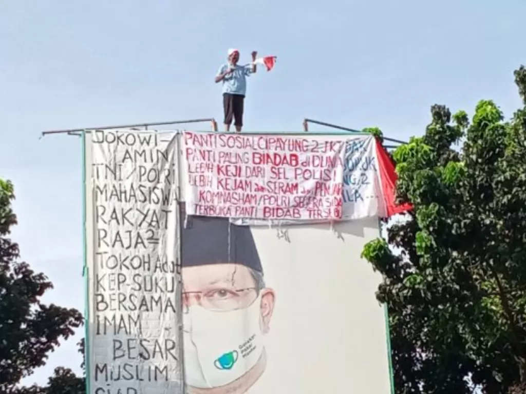 Agustinus Woro memanjat baliho di Jalan Pattimura, Kebayoran Baru, Jakarta Selatan, Selasa (24/11/2020). (ANTARA/HO/Satlantas Polres Metro Jakarta Selatan)