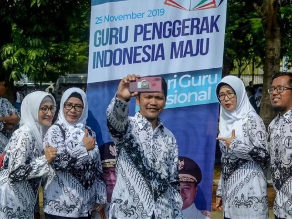 Sejumlah guru berswafoto usai upacara peringatan Hari Guru Nasional di Lapangan Gasibu, Bandung, Senin (24/11/2019). ANTARA FOTO/Raisan Al Farisi