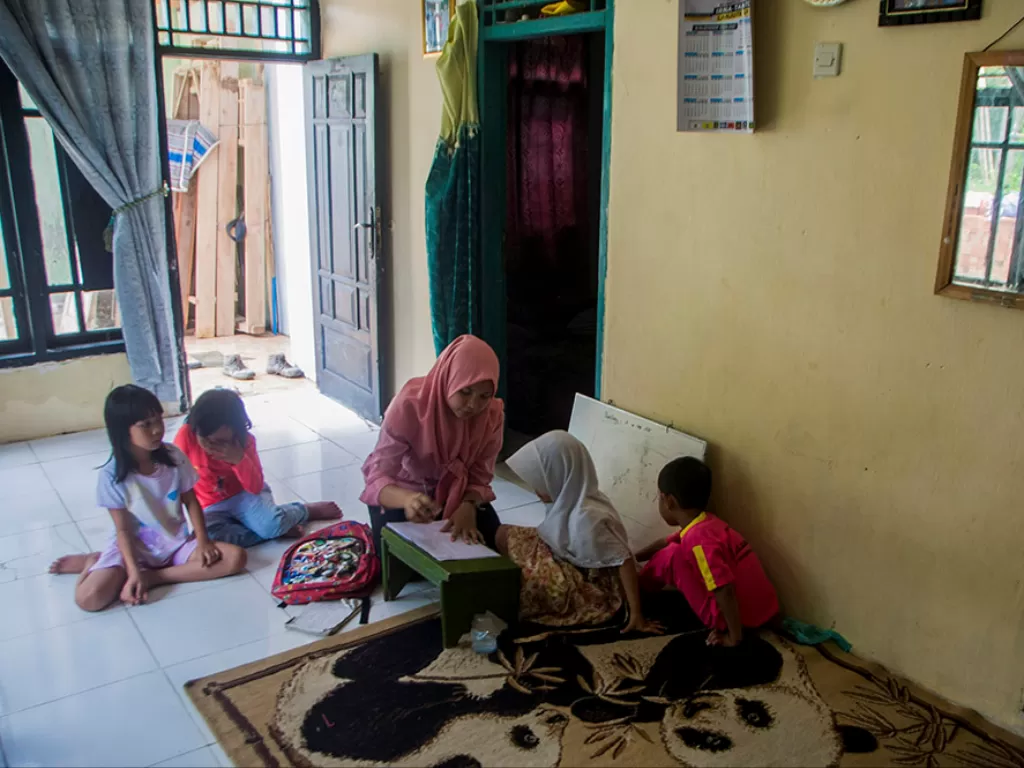 Guru memberikan bimbingan belajar kepada siswa PAUD Pelangi di rumahnya di Kampung Kanaga, Lebak, Banten, Rabu (25/11/2020). (Photo/Ilustrasi/ANTARA FOTO/Muhammad Bagus Khoirunas)
