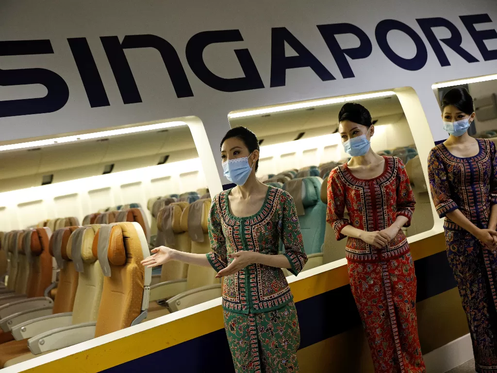Pramugari menyambut penumpang di pesawat Singapura. (REUTERS/EDGAR SU)