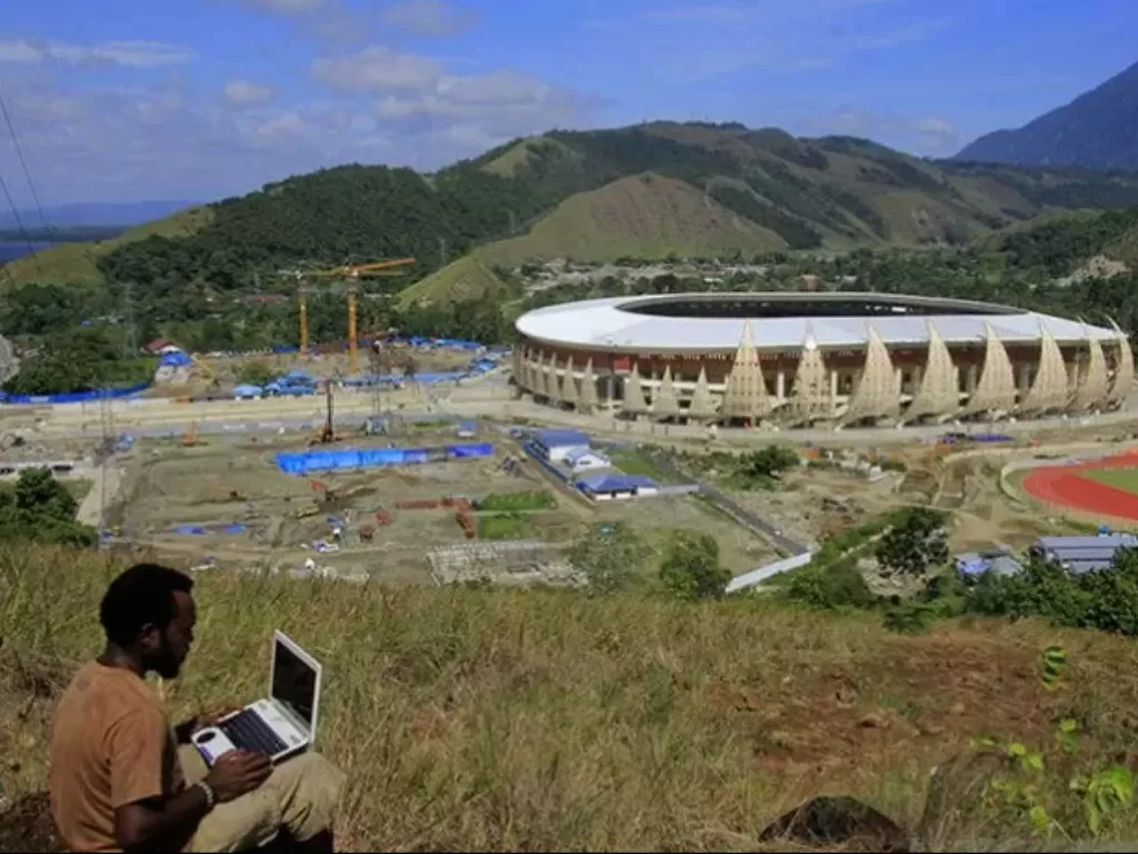 Warga menyaksikan proses pembangunan Kompleks Stadion Papua Bangkit di Distrik Sentani Timur, Kabupaten Jayapura, Papua, Jumat (15/3/2019). (Photo/ANTARA FOTO/Gusti Tanati)