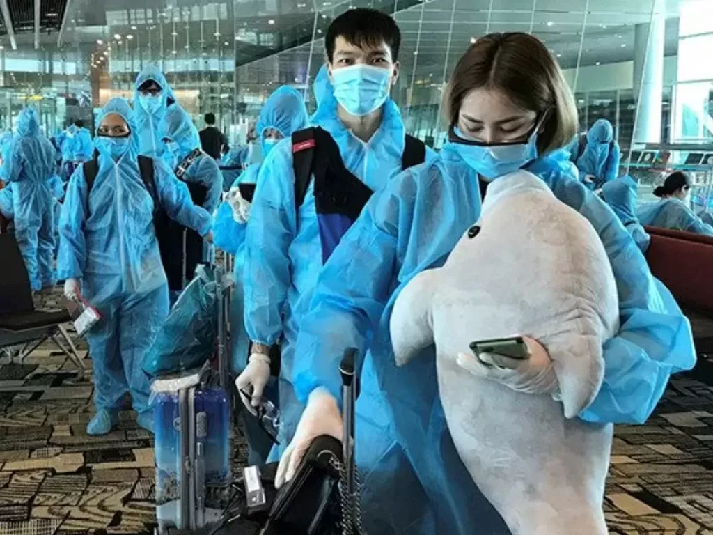 Seorang wanita Vietnam membawa boneka binatang saat akan naik penerbangan repatriasi dari Singapura menuju Vietnam ditengah penyebaran virus corona (COVID-19) di bandara Changi, Singapura, Jumat (7/8/2020). (Photo/REUTERS/Mai Nguyen)