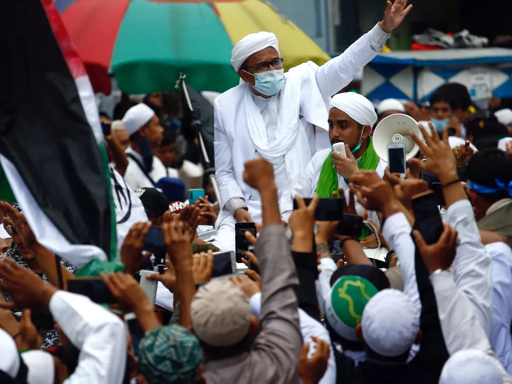 Habib Rizieq Shihab melambaikan tangan di antara massa pendukungnya. ( REUTERS/Ajeng Dinar Ulfiana).