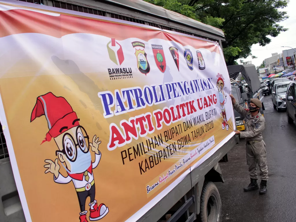 Petugas Satpol PP memasang spanduk pada truk yang digunakan untuk patroli pengawasan anti politik uang (ANTARA FOTO/Arnas Padda)