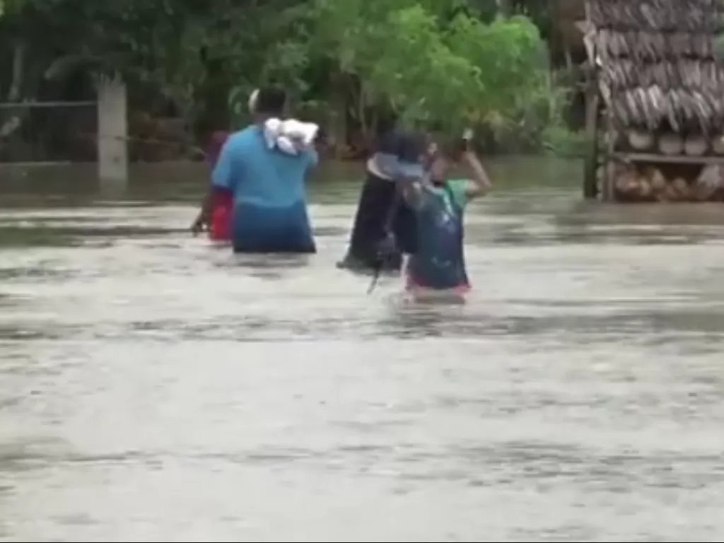 Warga menerobas banjir untuk mengungsi ke tempat yang lebih aman (Foto: Tangkapan layar video Antara)