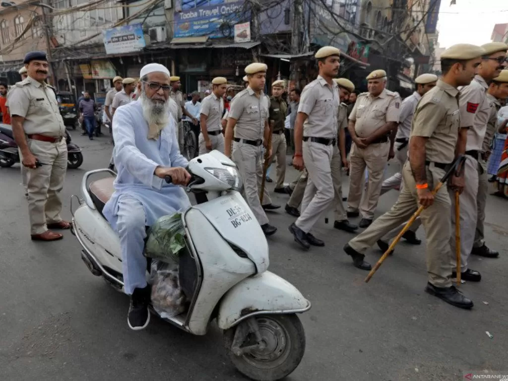 Dokumentasi--Seorang pria Muslim mengendarai skuter saat polisi melakukan pawai bendera di luar Mesjid Jama, sebelum putusan Mahkamah Agung tentang sengketa tempat relijius yang diklaim oleh umat Hindu dan Muslim di Ayodhya, di kota tua Delhi, India, Sabt