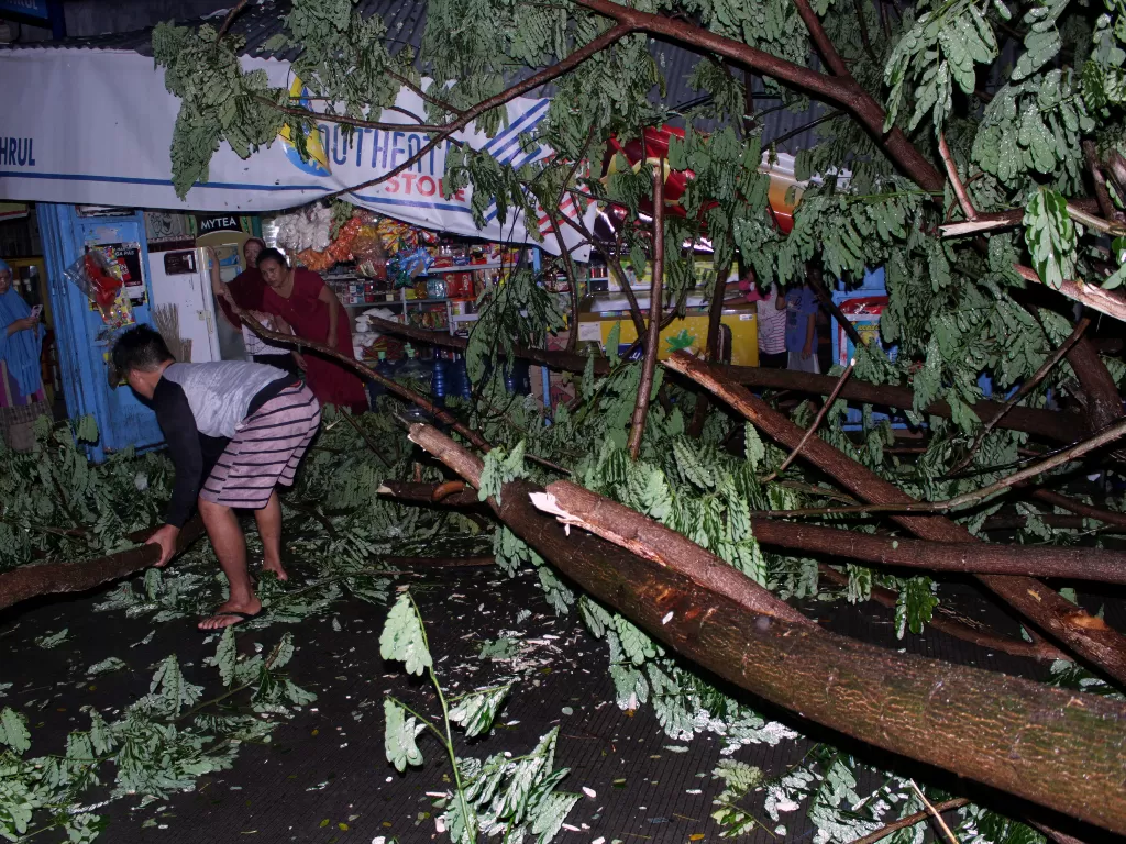 Warga membersihkan pohon tumbang yang menutupi Jalan Syech Yusuf (ANTARA FOTO/Arnas Padda)