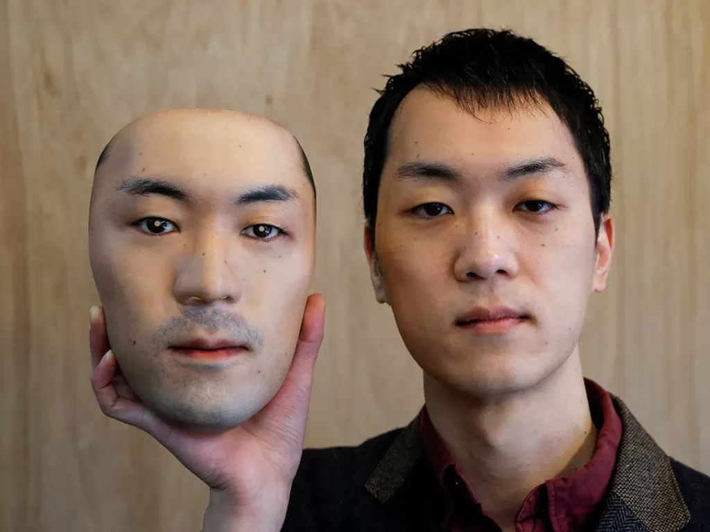 Shuhei Okawara, 30, pemilik toko topeng Kamenya Omote, memegang masker wajah super realistik berdasarkan wajah aslinya, dibuat dengan menggunakan teknologi cetak 3D, di Tokyo. (Photo/REUTERS/Issei Kato)