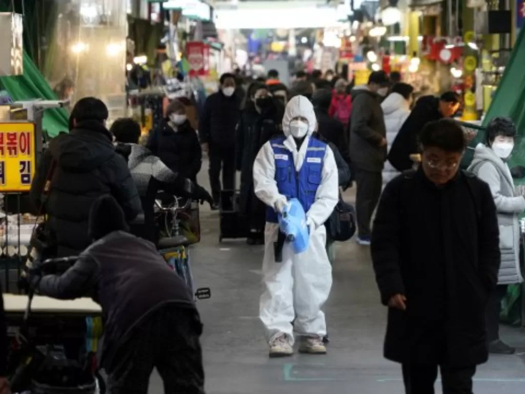 Seorang karyawan dari perusahaan layanan disinfeksi membersihkan lantai pasar tradisional di Kota Seoul, Korea Selatan, Senin (24/2/2020). (REUTERS/Kim Hong-Ji)