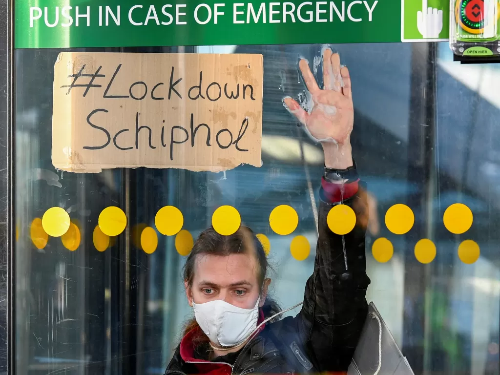 Seorang aktivis lingkungan protes menempel di pintu masuk untuk memblokir Bandara Schiphol Amsterdam (REUTERS/Piroschka van de Wouw)