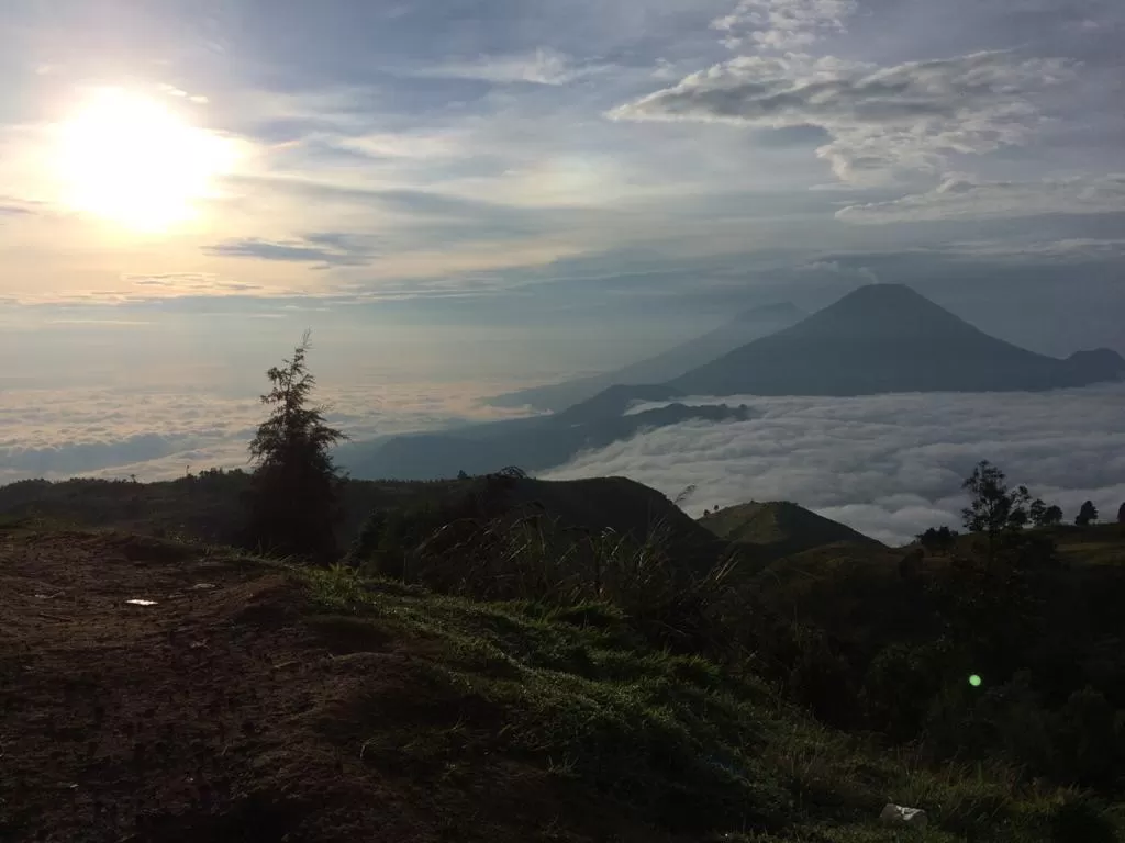 Gunung Sumbing, Gunung Slamet, dan Gunung Sindoro terlihat di seberang lautan awan di atas puncak Gunung Prau. (Foto: Indozone/Abul Muamar)