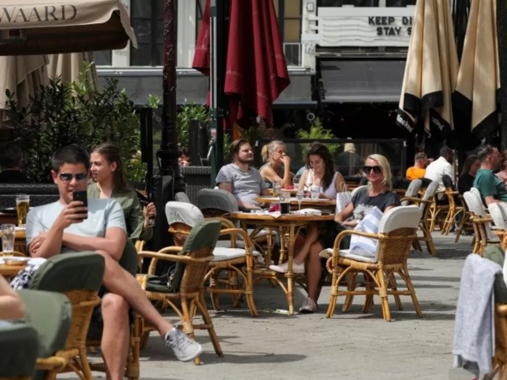 Pengunjung menikmati minuman mereka di kafe yang buka kembali di Leidseplein Square, seiring Belanda melonggarkan sejumlah aturan untuk memerangi virus corona (COVID-19), di Amsterdam, Belanda. (ANTARA FOTO/REUTERS/Eva Plevier/pras/djo)