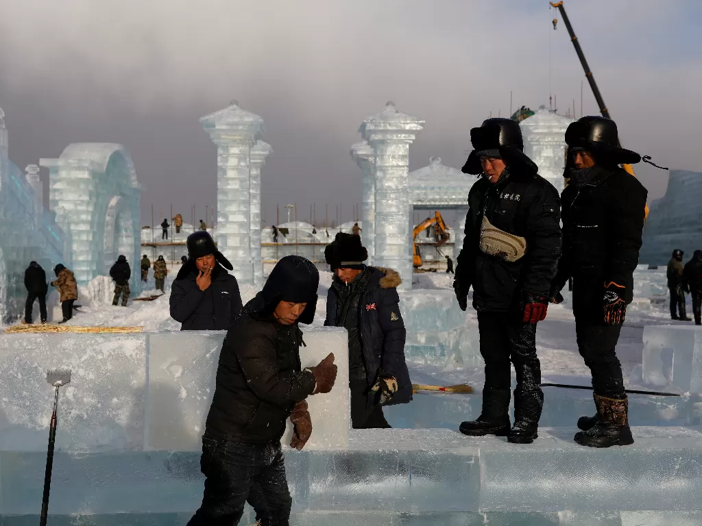 Para pekerja Tiongkok sedang membangun kastil es. (REUTERS/CARLOS GARCIA RAWLINS)