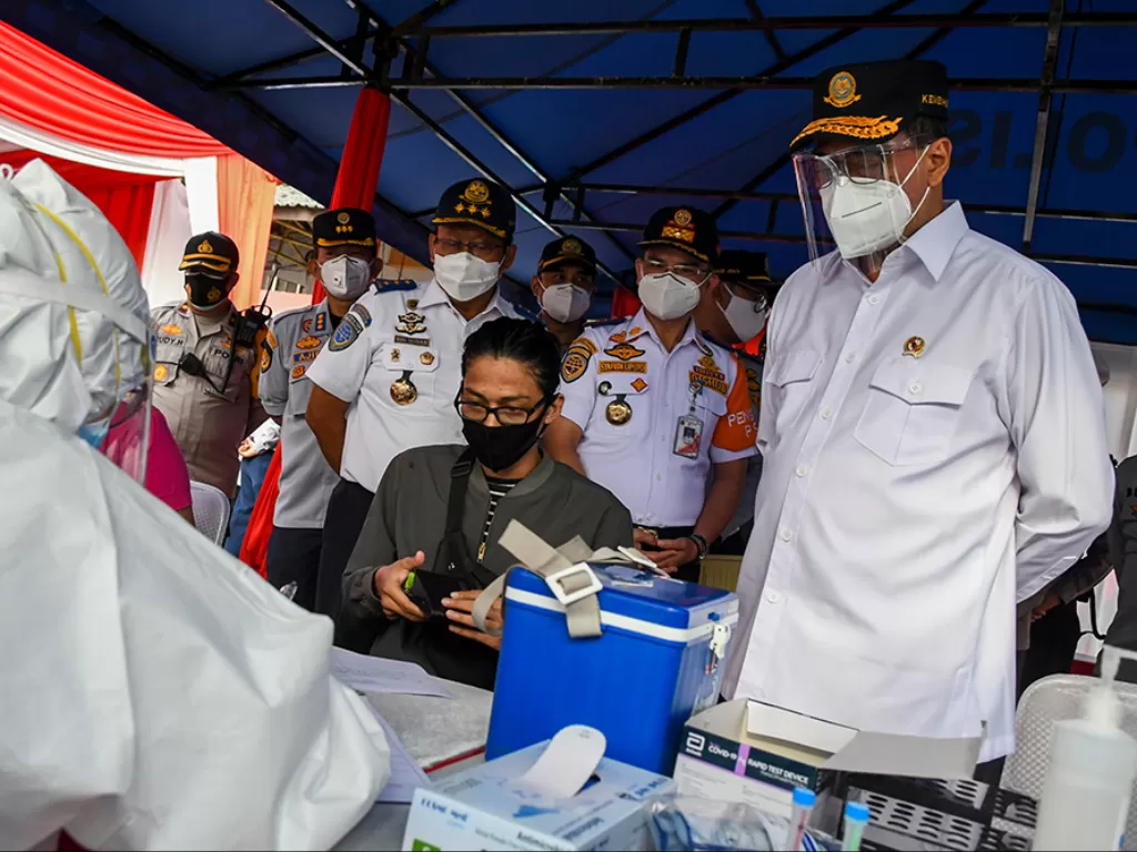 Menteri Perhubungan Budi Karya Sumadi (tengah) menyaksikan pemeriksaan tes cepat antigen untuk calon penumpang bus Angkutan Kota Antar Provinsi. (Photo/ANTARA FOTO/Galih Pradipta)