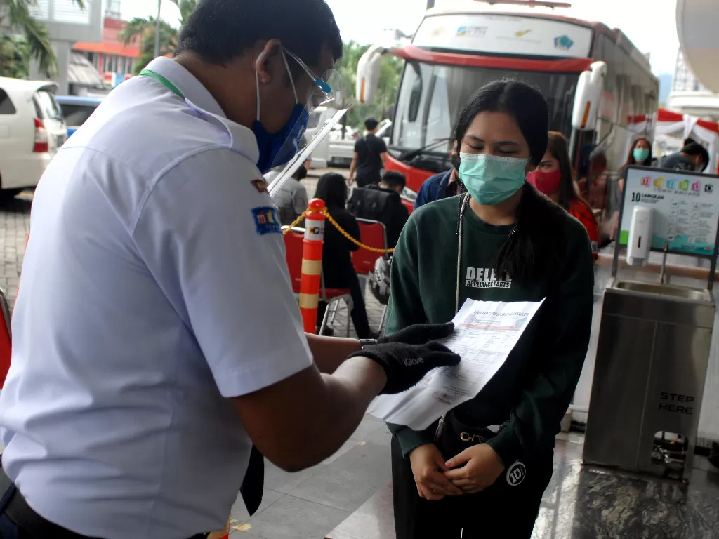 Petugas keamanan memeriksa surat keterangan hasil tes cepat (ANTARA FOTO/Adwit B Pramono)