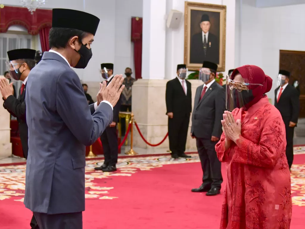 Presiden Joko Widodo memberikan ucapan selamat kepada Menteri Sosial Tri Rismaharini saat upacara pelantikan menteri Kabinet Indonesia Maju di Istana Negara, Jakarta, Rabu (23/12/2020). (ANTARA/BPMI Setpres/Muchlis Jr)