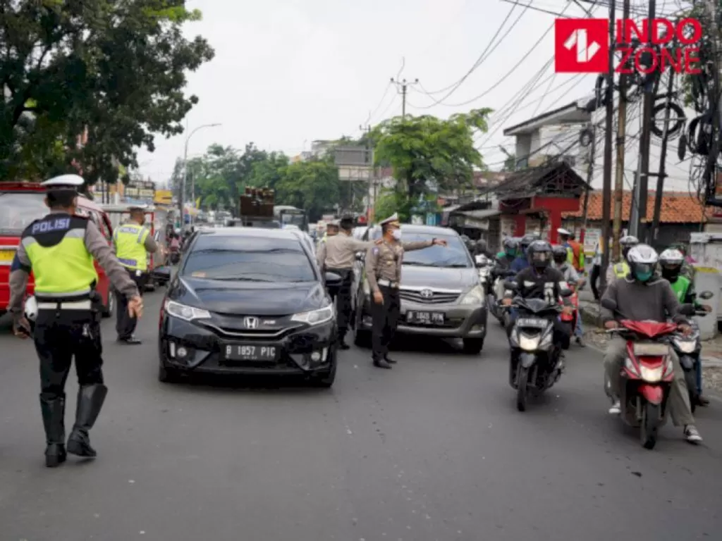 Petugas menghimbau pengguna kendaraan bermotor saat melakukan Pengawasan Pelaksanaan PSBB di Jalan Ciledug Raya, Jakarta, Senin (13/4/2020). (INDOZONE)