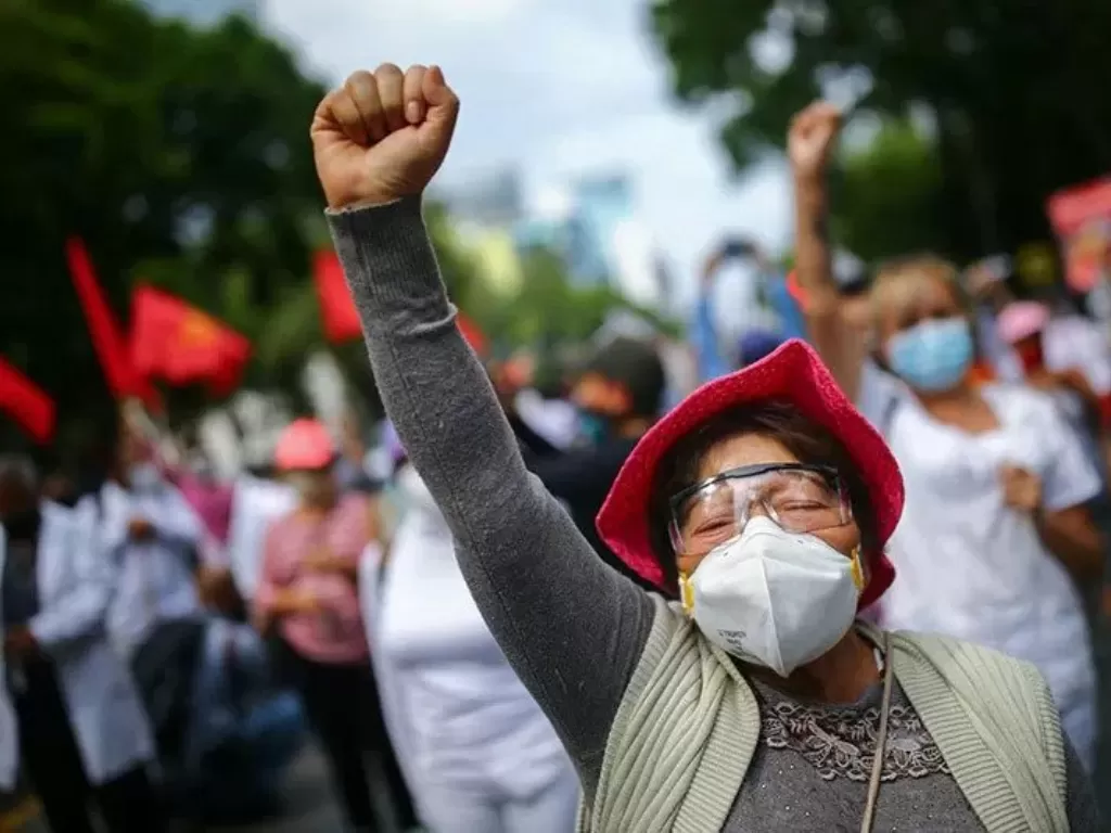 Seorang pekerja kesehatan mengikuti demonstrasi meminta pemerintah Meksiko menyediakan kondisi bekerja yang lebih baik kepada pekerja rumah sakit. (REUTERS/Edgard Garrido)