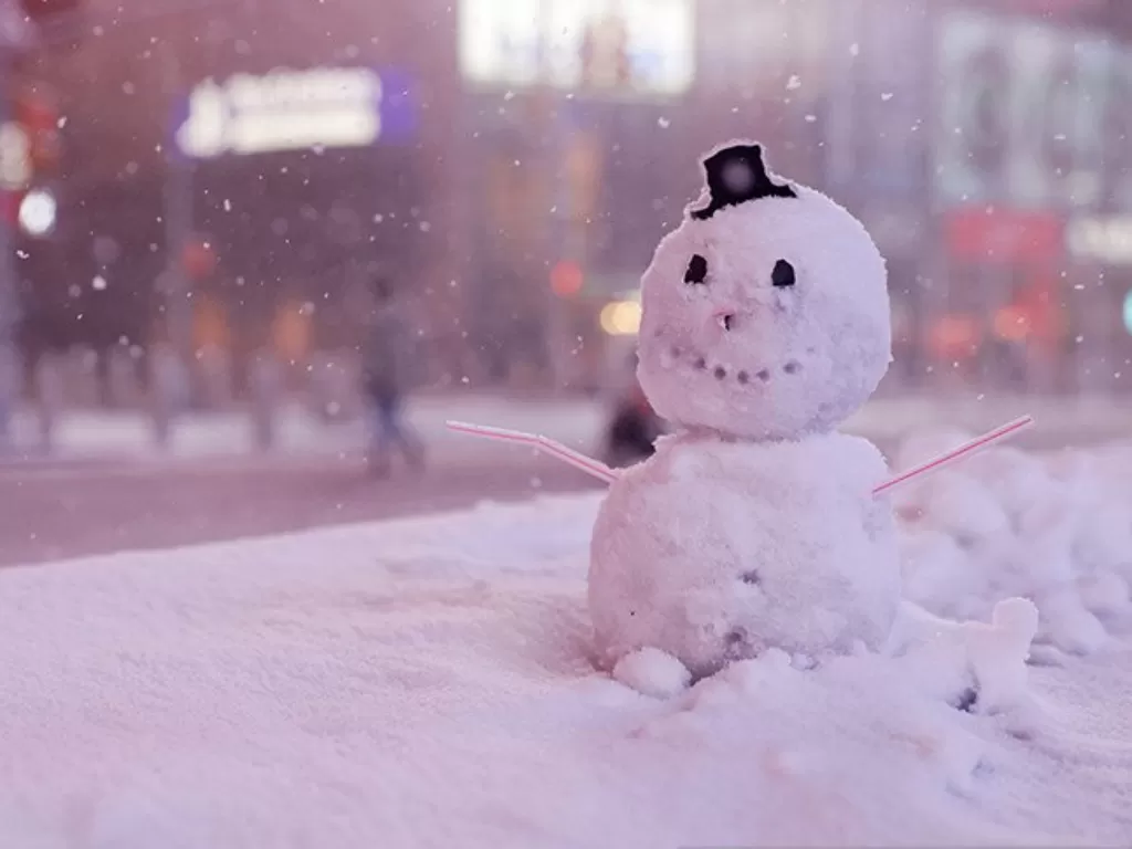 Manusia salju terlihat saat salju mulai turun di Times Square di tengah wabah pandemi Covid-19 di wilayah Manhattan di New York City, New York, AS, (16/12/2020). (REUTERS/Jeenah Moon)