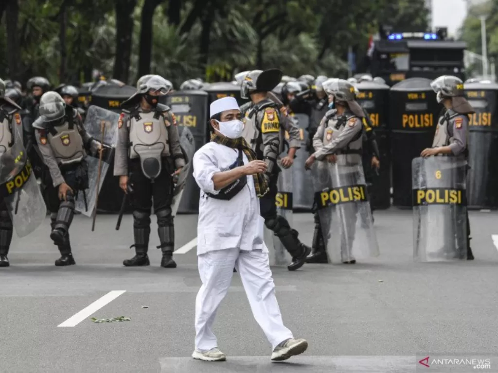 Seorang pengunjuk rasa aksi demonstrasi 1812 berjalan saat membubarkan diri, di kawasan Medan Merdeka Selatan, Jakarta, Jumat (18/12/2020). Kepolisian membubarkan paksa massa aksi demonstrasi dikarenakan angka