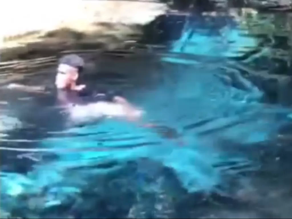 Seorang pemuda berenang di telaga yang memiliki air benis seperti kaca (ist)