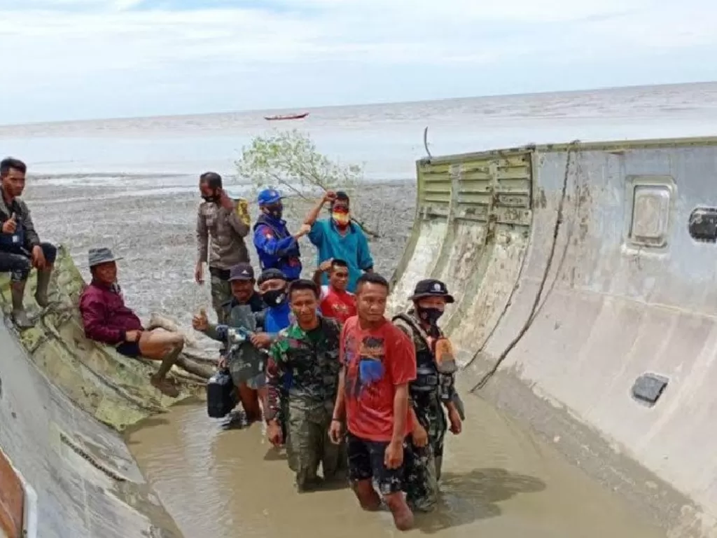 Tim gabungan bersama warga Kotawaringin Barat, Kalimantan Tengah melakukan pengecekan benda atau serpihan yang diduga bangkai pesawat terbang yang ditemukan di perairan Kumai. (foto: Humas Polda Kalteng)