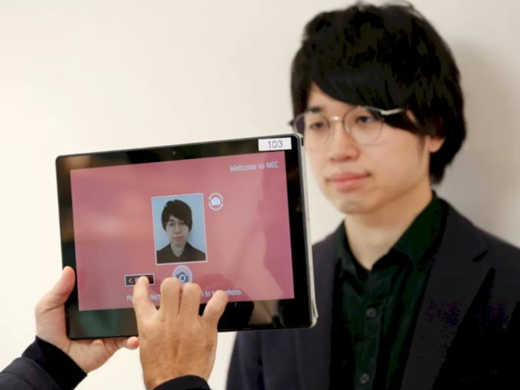 Staf NEC mengambil foto Shinya Takashima untuk pendaftaran (REUTERS/Kim Kyung-Hoon)