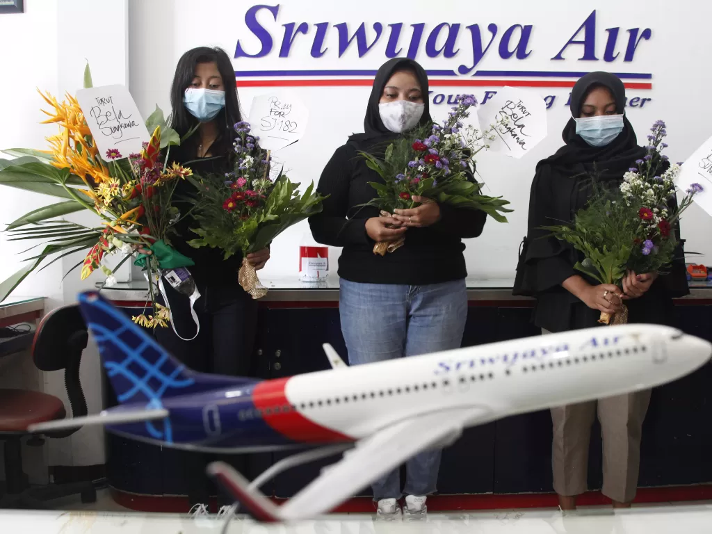 Warga membawa bunga dan berdoa bersama bagi para korban kecelakaan pesawat Sriwijaya Air SJ182 di Solo, Jawa Tengah, Minggu (10/1/2021). (photo/ANTARA FOTO/Maulana Surya)