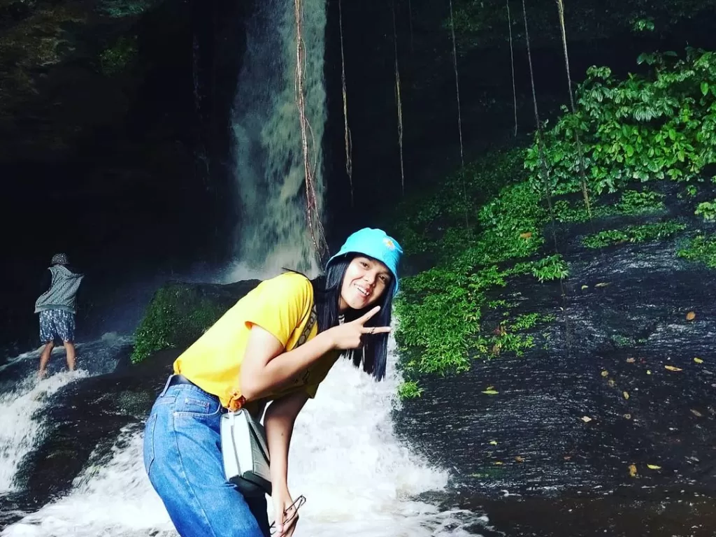 Seorang pengunjung mengabadikan foto di air terjun Seribu Gua Dolok Pinapan, Pakkat. (Instagram/seribuguabanuarea_tourguide)