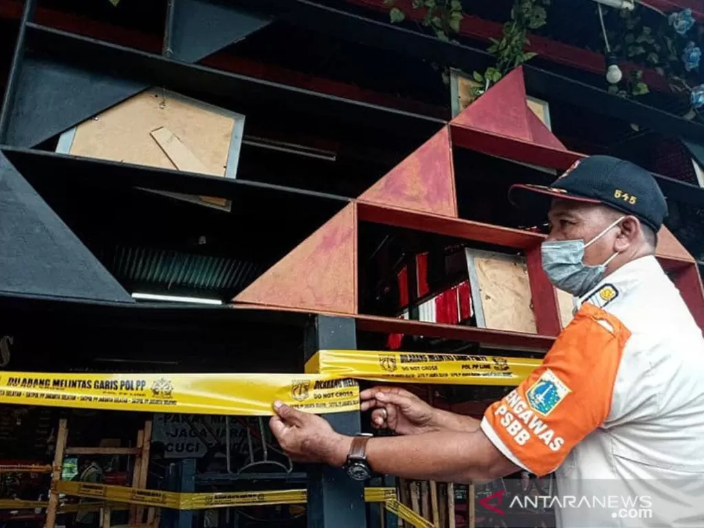 Petugas Satpol PP menyegel salah satu tempat usaha di Kelurahan Cipete Utara, Jakarta Selatan, karena melanggar protokol kesehatan, Jumat (11/12/2020).  (photo/ANTARA/HO-Kominfotik Jaksel)