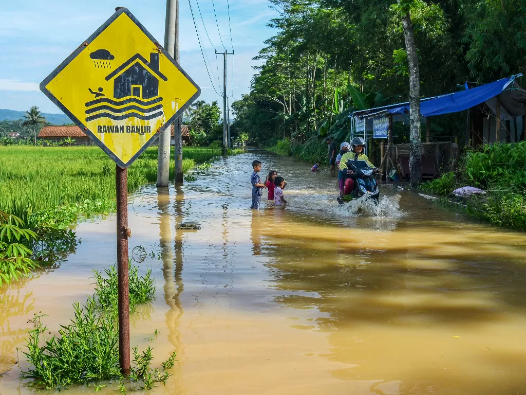 Pengendara menerobos banjir (ANTARA FOTO/Adeng Bustomi)
