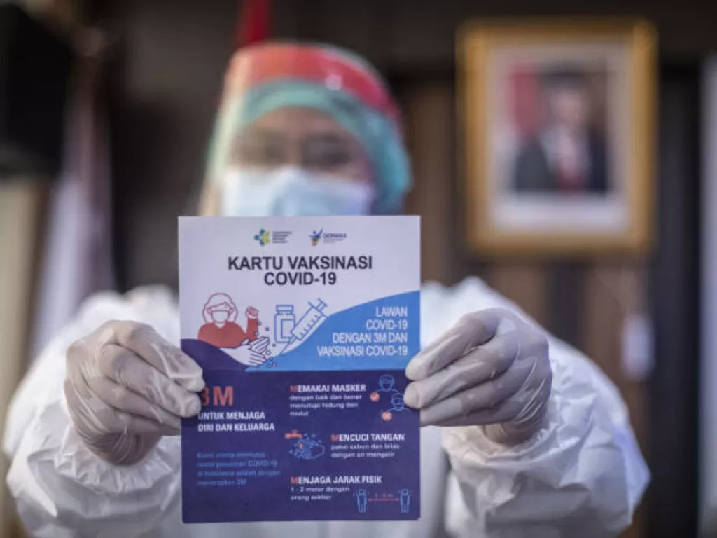Petugas medis menunjukkan kartu vaksinasi COVID-19 (ANTARA FOTO/Aprillio Akbar)