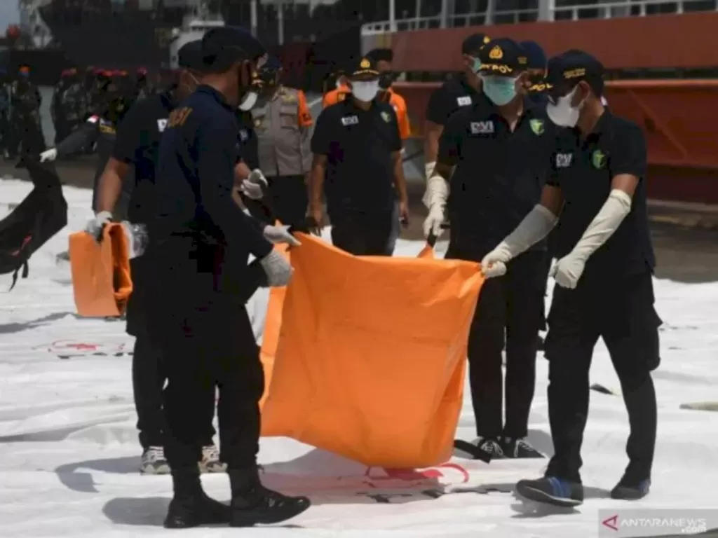 Petugas membawa kantong jenazah berisi bagian tubuh korban pesawat Sriwijaya Air SJ 182 di Dermaga JICT, Jakarta, Senin (11/1/2021). (ANTARA FOTO/Akbar Nugroho Gumay)