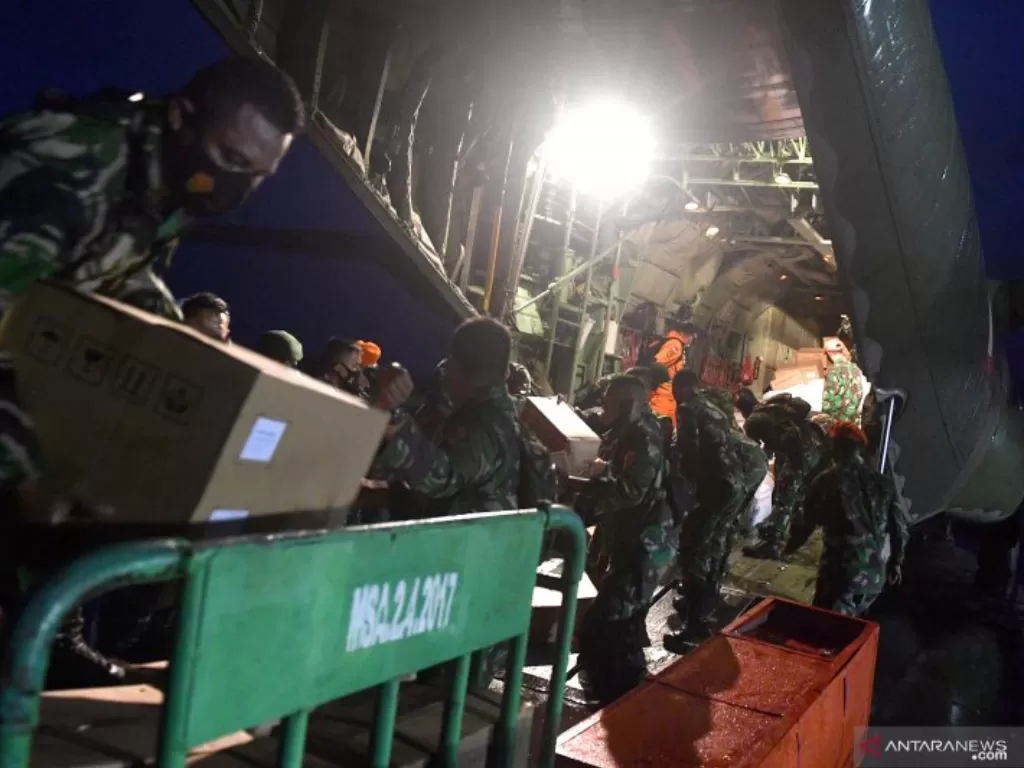 Prajurit TNI dan anggota Basarnas mengeluarkan logistik untuk korban gempa bumi Mamuju dan Majene dari pesawat Hercules A 1321 TNI AU saat tiba di Bandara Tampa Padang, Mamuju, Sulawesi Barat, Jumat (15/1/2021).  (photo/ANTARA FOTO/Sigid Kurniawan)