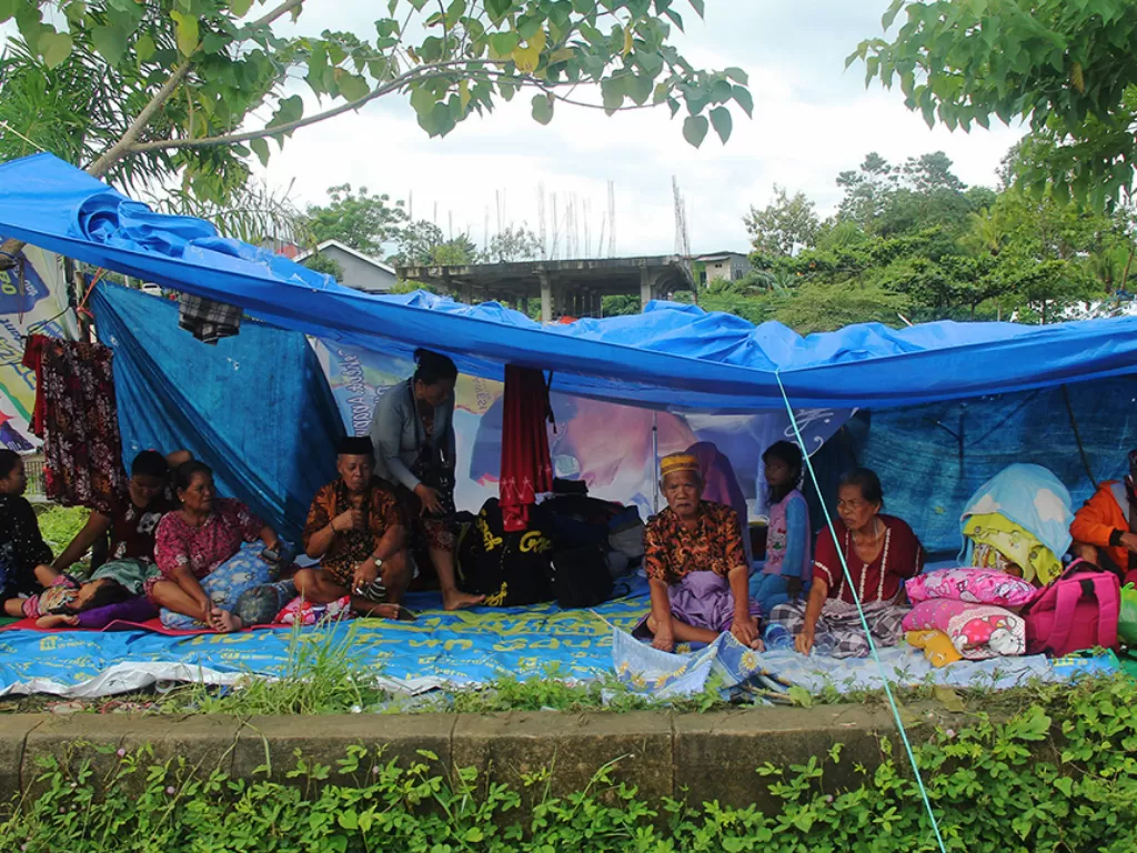 Sejumlah warga mengungsi di ketinggian di Mamuju Sulawesi Barat, Sabtu (15/1/2021). Menurut warga, bantuan logistik belum tersalurkan di tempat pengungsian. (Photo/ANTARA FOTO/Akbar Tado)