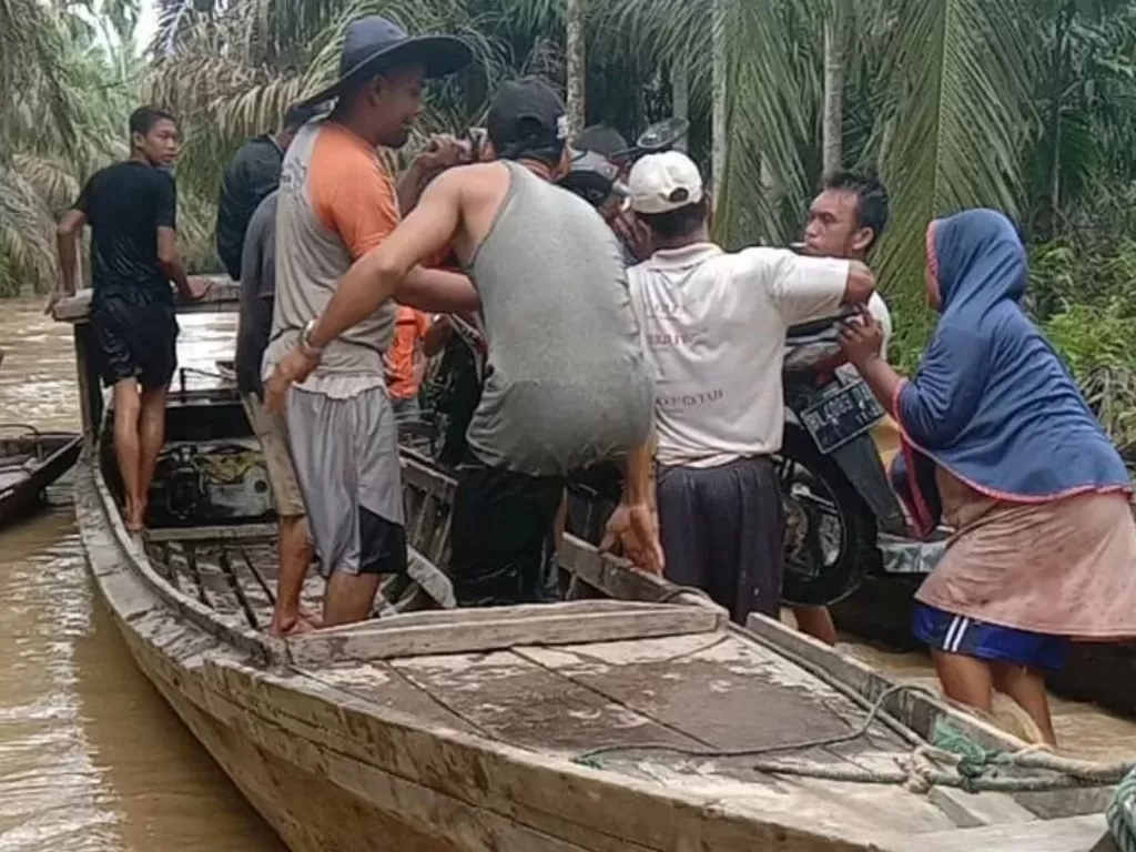 Warga menaiki sampan untuk mengungsi menyusul banjir yang melanda kampung mereka di Kecamatan Bandar Pusaka, Aceh Tamiang (Antara)