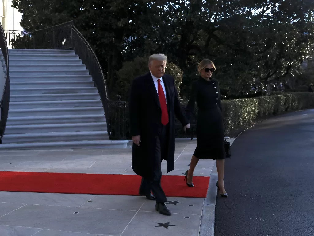 Presiden AS Donald Trump dan ibu negara Melania Trump meninggalkan Gedung Putih menjelang dilantiknya Joe Biden di Washington, AS, Rabu (20/1). (photo/REUTERS/Leah Millis)