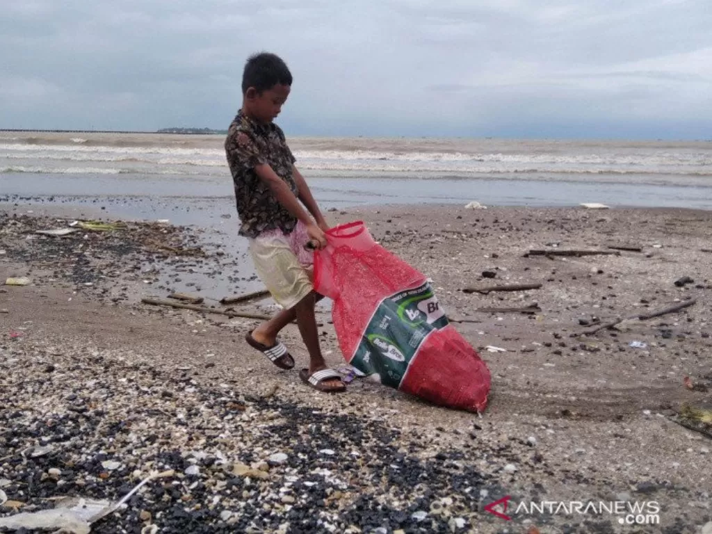 Seorang anak tengah menyeret karung plastik yang berisi batu bara (ANTARA/Akhmad Nazaruddin Lathif)