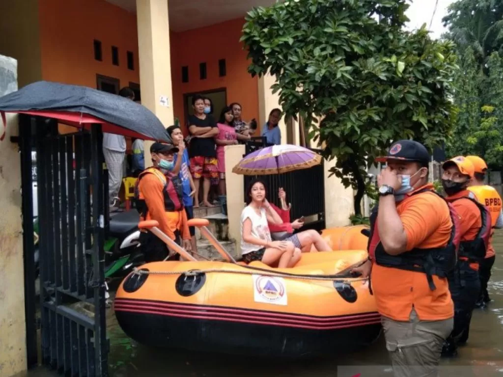 Personel BPBD Kota Bekasi mengevakuasi warga terdampak banjir. (photo/ANTARA/Istimewa)