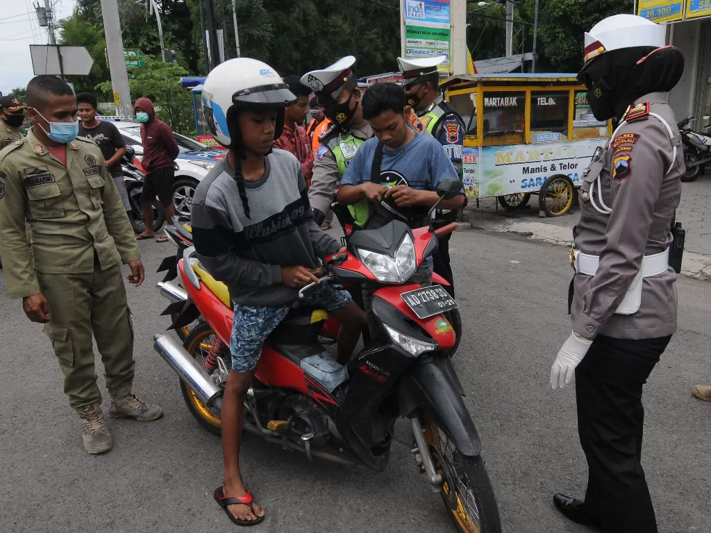 Petugas gabungan memberhentikan pengendara motor yang tidak menggunakan masker saat melakukan razia yustisi.  (Foto: ANTARA/Aloysius Jarot Nugroho)