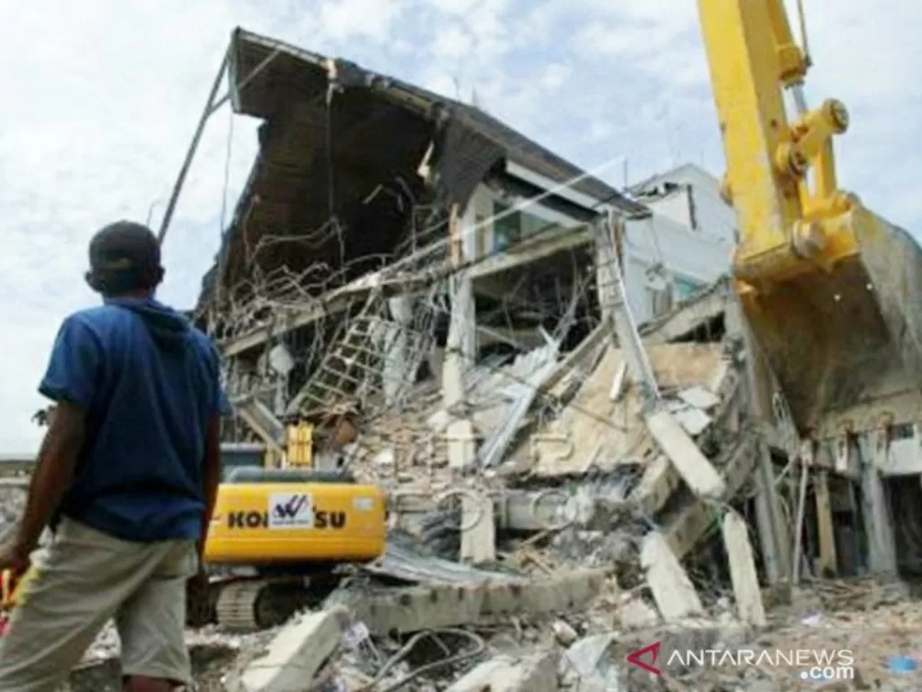 Sejumlah alat berat membersihkan puing reruntuhan bangunan Kantor Gubernur Sulbar, Mamuju, Sulawesi Barat, Rabu (20/1/2021).  (photo/ANTARA FOTO / Akbar Tado)