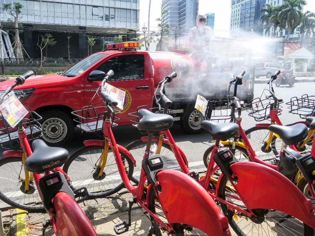 Petugas BIN melakukan penyemprotan cairan disinfektan ke arah sepeda sewa yang berada di Jalan Medan Merdeka Timur (ANTARA FOTO/M Risyal Hidayat)