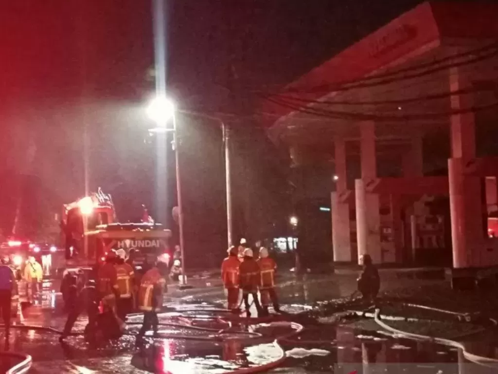  Petugas pemadam kebakaran di lokasi SPBU Margomulyo Surabaya, Minggu (24/1) malam. (ANTARA Jatim/Hanif Nashrullah)