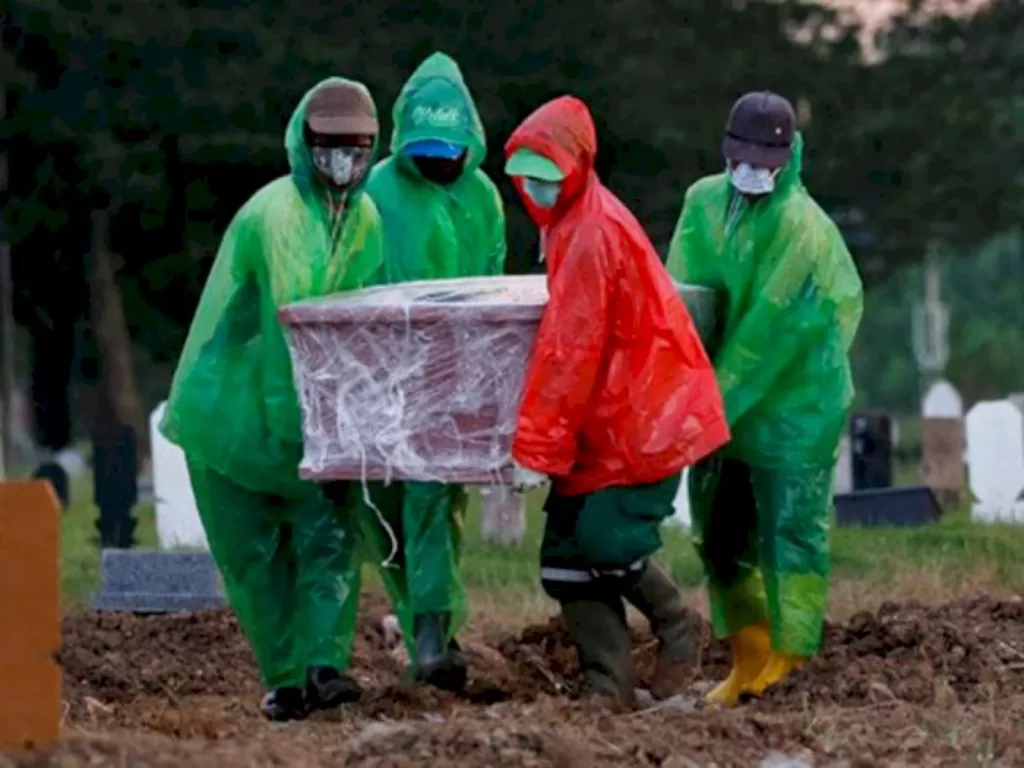 Pemakaman jenazah dengan protokol pasien virus corona. (REUTERS/Willy Kurniawan)
