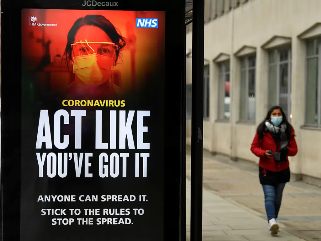 Tanda informasi kesehatan masyarakat pemerintah Inggris terlihat di halte bus di London. (Photo/REUTERS/Toby Melville)